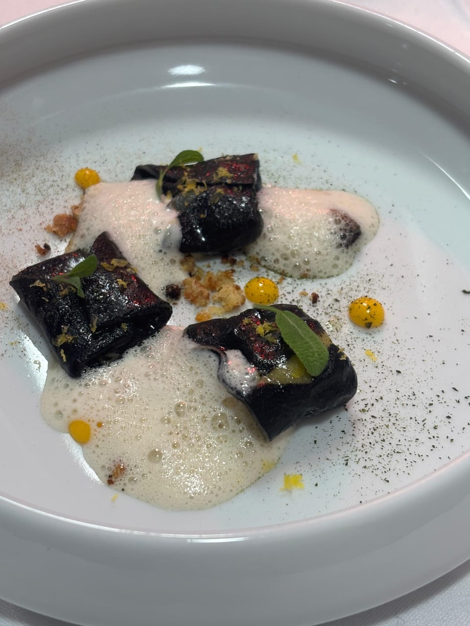 Raviole bicolore courge et lard, jaune d'oeuf confit et émulsion champignon