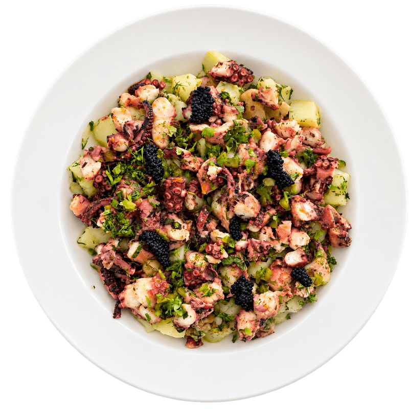 Salade de poulpe aux herbes et perles noires dans une assiette blanche